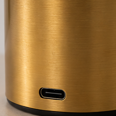 Gold-colored cylindrical object with a USB port on a light gray background